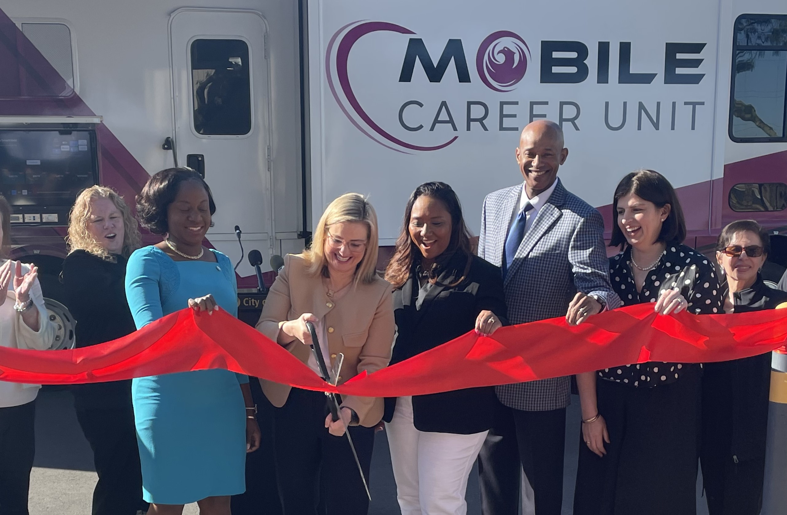 A group of people at a ceremonial ribbon-cutting event